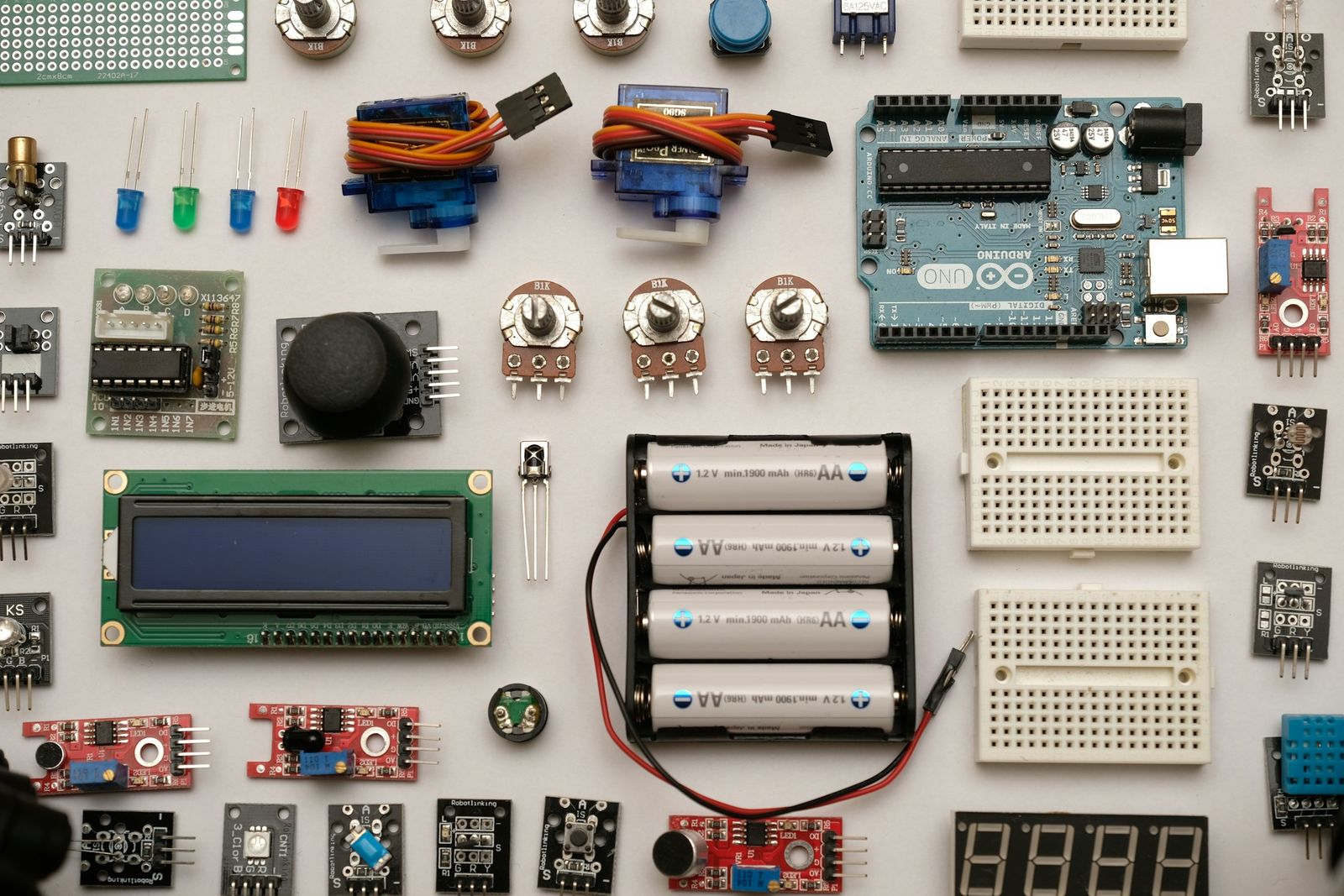 Hands working on a populated circuit board at an assembly bench.