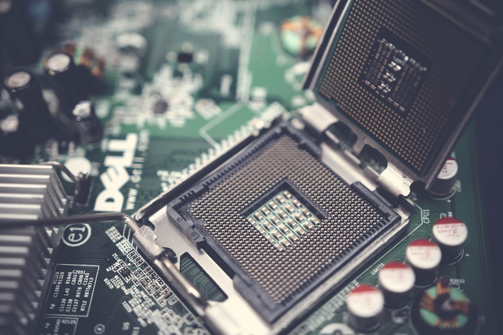 Macro photograph of a printed circuit board showing an IC package, dense pad arrays and fine traces.